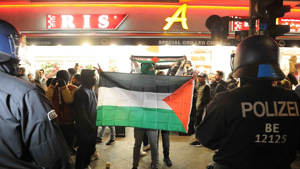 Ein Vermummter zeigt die Palästina-Flagge