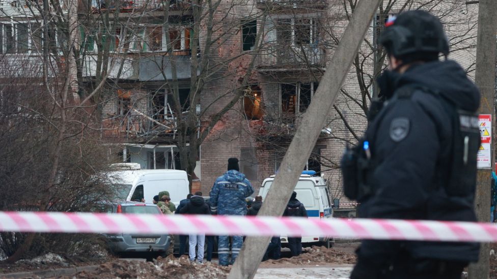 Emergency services specialists work by a damaged apartment block after an alleged drone attack reported by local media, in Saint Petersburg